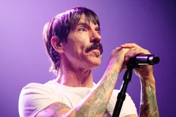 Anthony Kiedis durante show do Red Hot Chili Peppers segurando o microfone no palco