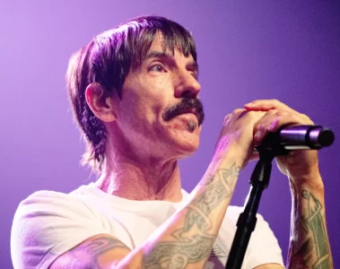 Anthony Kiedis durante show do Red Hot Chili Peppers segurando o microfone no palco