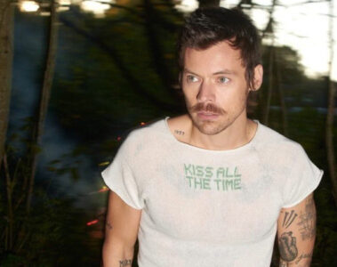 Harry Styles em imagem promocional usando camiseta com o nome do novo álbum Kiss All the Time
