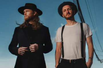Integrantes do The Lumineers em foto promocional da era Automatic World Tour