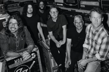 Foo Fighters reunidos em estúdio com equipamentos e amplificadores ao fundo