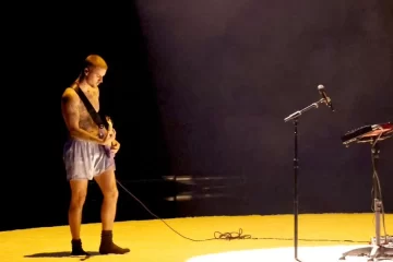 Justin Bieber durante apresentação no Grammy Awards 2026, tocando guitarra em performance minimalista.