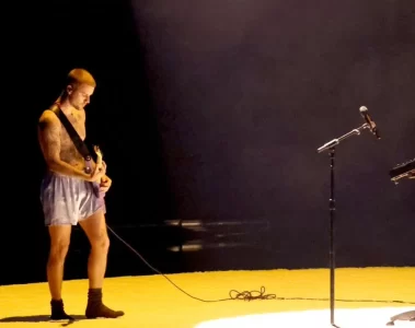 Justin Bieber durante apresentação no Grammy Awards 2026, tocando guitarra em performance minimalista.