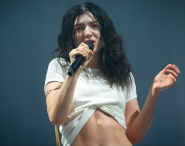 Lorde se apresentando ao vivo em show, cantando no palco durante turnê internacional
