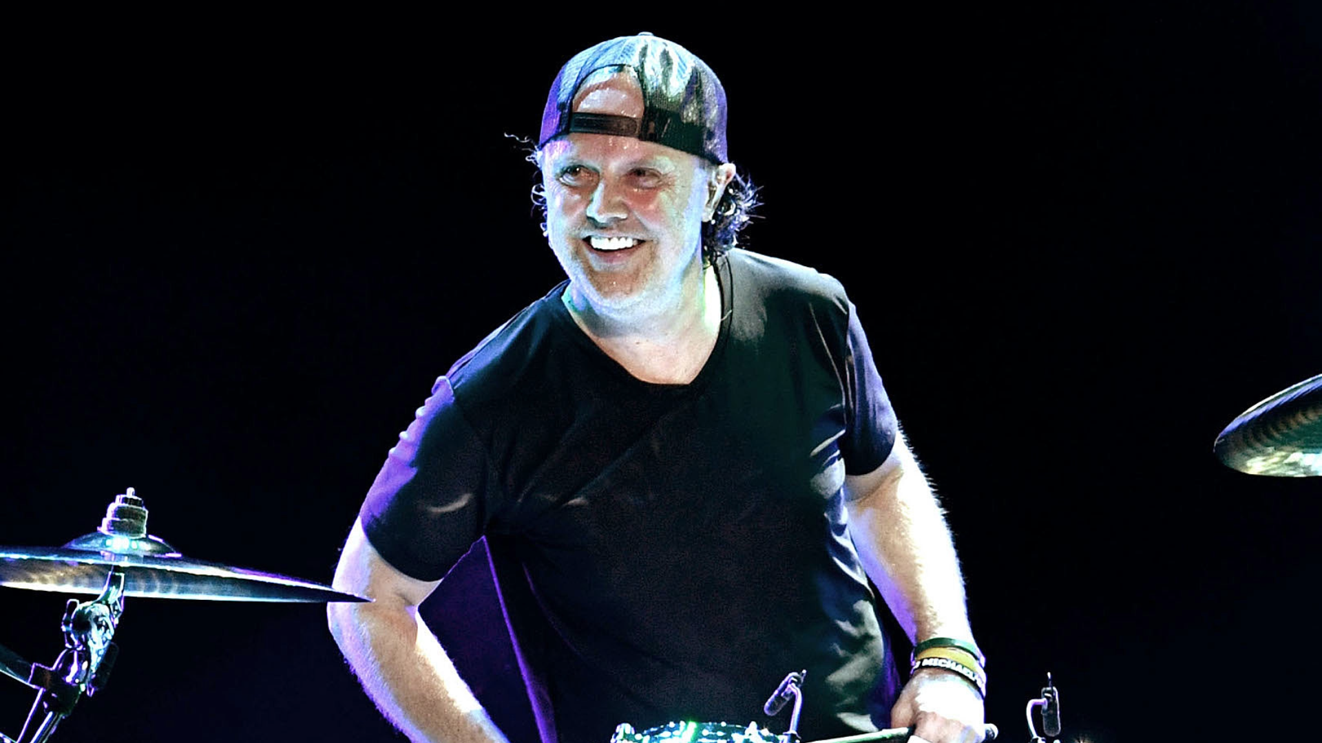 Lars Ulrich tocando bateria durante apresentação ao vivo do Metallica.