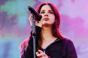 Lana Del Rey cantando ao vivo em show, com microfone no palco