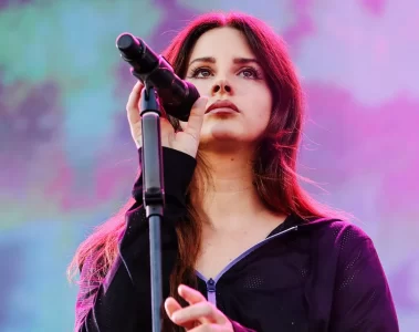 Lana Del Rey cantando ao vivo em show, com microfone no palco