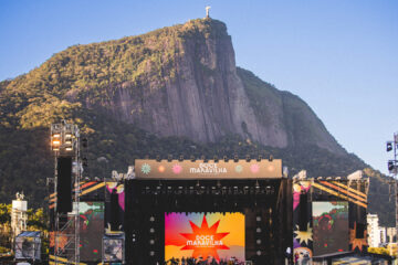 Palco do festival Doce Maravilha com público no Jockey Club e Cristo Redentor ao fundo no Rio de Janeiro
