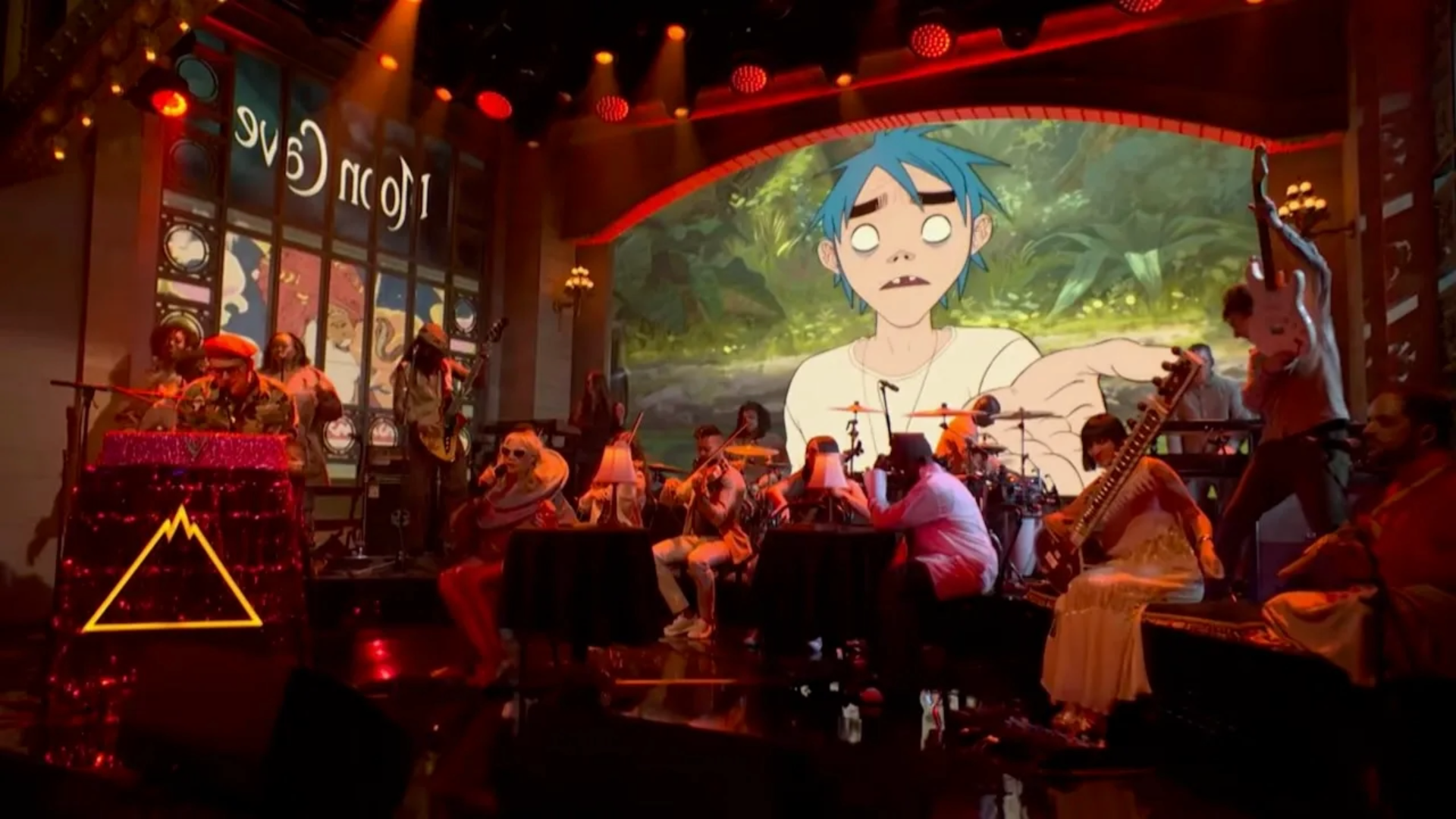 Gorillaz se apresentando no Saturday Night Live com projeção animada da banda ao fundo