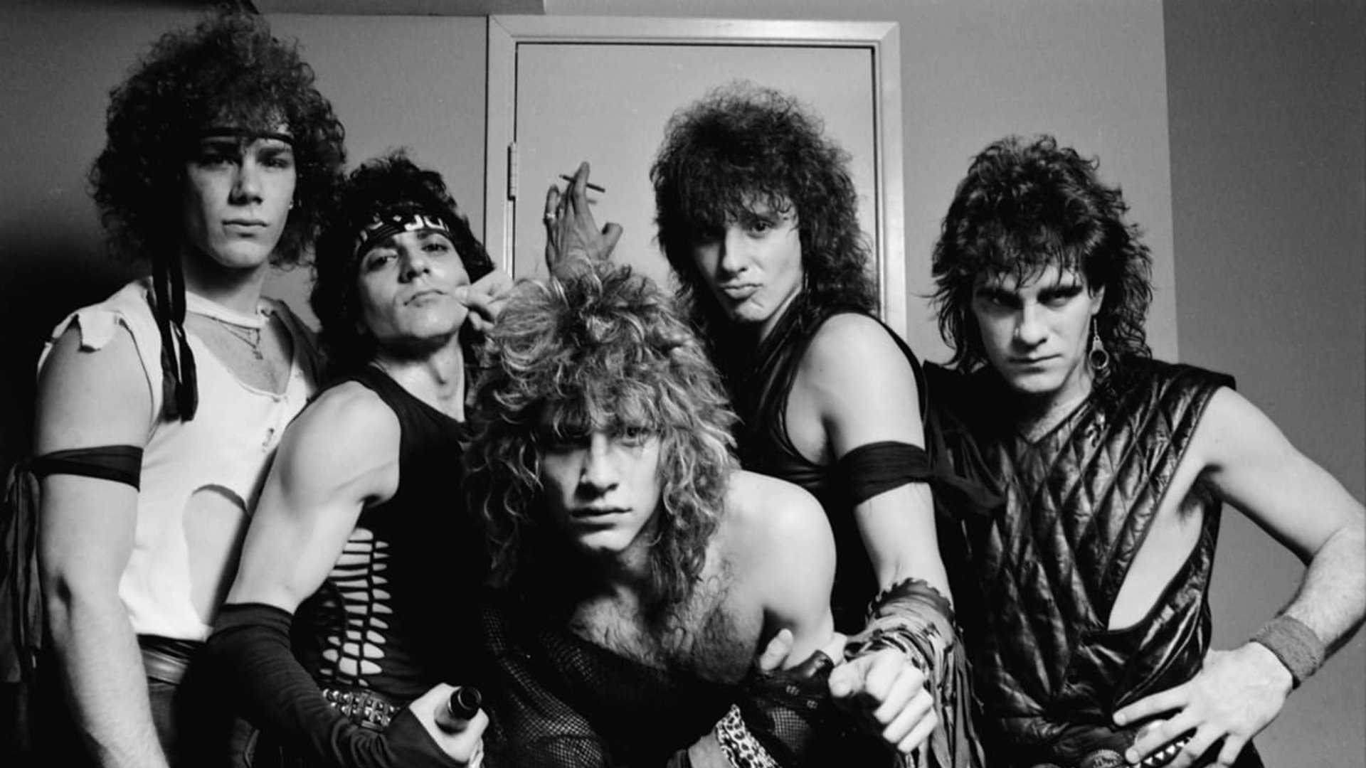 Banda Bon Jovi em foto promocional dos anos 1980 com Jon Bon Jovi e integrantes durante a era glam rock.