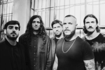 Rancore posando em foto preto e branco em frente a janelas industriais