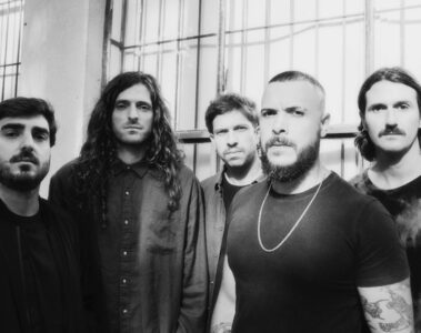 Rancore posando em foto preto e branco em frente a janelas industriais