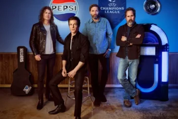 The Killers posando em estúdio com logo da Pepsi e Champions League ao fundo
