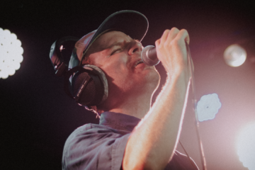 Mac DeMarco canta ao vivo durante show no Sacadura 154, no Rio de Janeiro, com iluminação intensa no palco