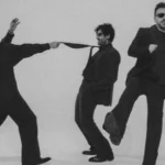 banda Fresno em ensaio fotográfico com ternos pretos e fundo neutro