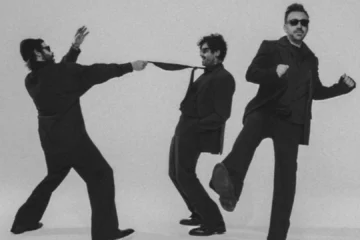 banda Fresno em ensaio fotográfico com ternos pretos e fundo neutro