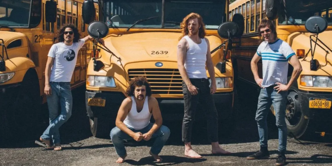 banda Sticky Fingers posando em frente a ônibus amarelos durante divulgação de turnê