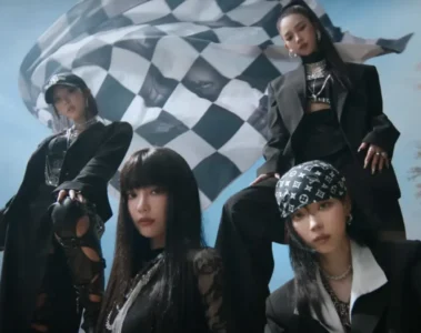 Integrantes do aespa em cena do clipe Rich Man com figurino preto e bandeira ao fundo