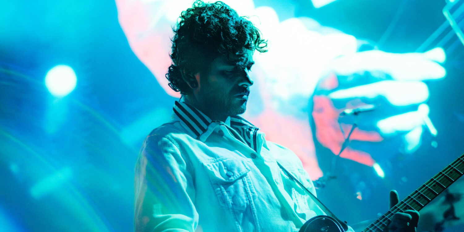 Guitarrista da Fresno durante apresentação da turnê de Carta de Adeus na Fundição Progresso, no Rio de Janeiro, com iluminação azul no palco