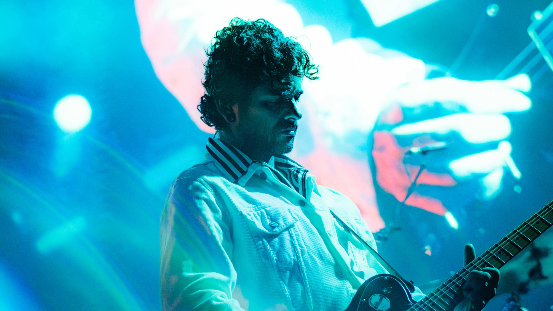 Guitarrista da Fresno durante apresentação da turnê de Carta de Adeus na Fundição Progresso, no Rio de Janeiro, com iluminação azul no palco