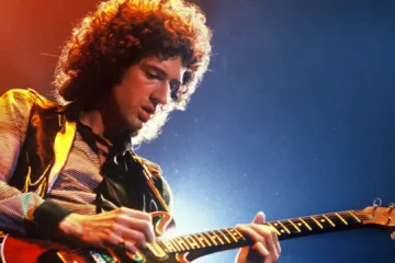 Brian May tocando guitarra em apresentação ao vivo do Queen