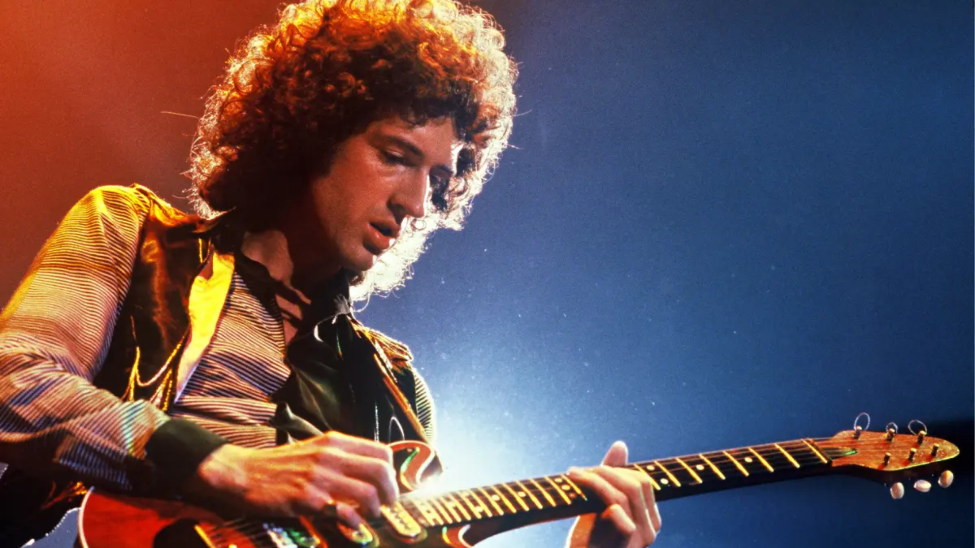 Brian May tocando guitarra em apresentação ao vivo do Queen