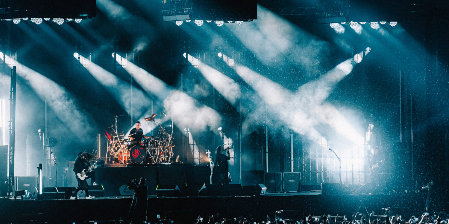 Korn durante show no Nubank Parque em São Paulo com iluminação intensa e estádio lotado