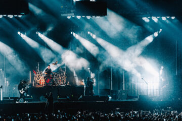 Korn durante show no Nubank Parque em São Paulo com iluminação intensa e estádio lotado