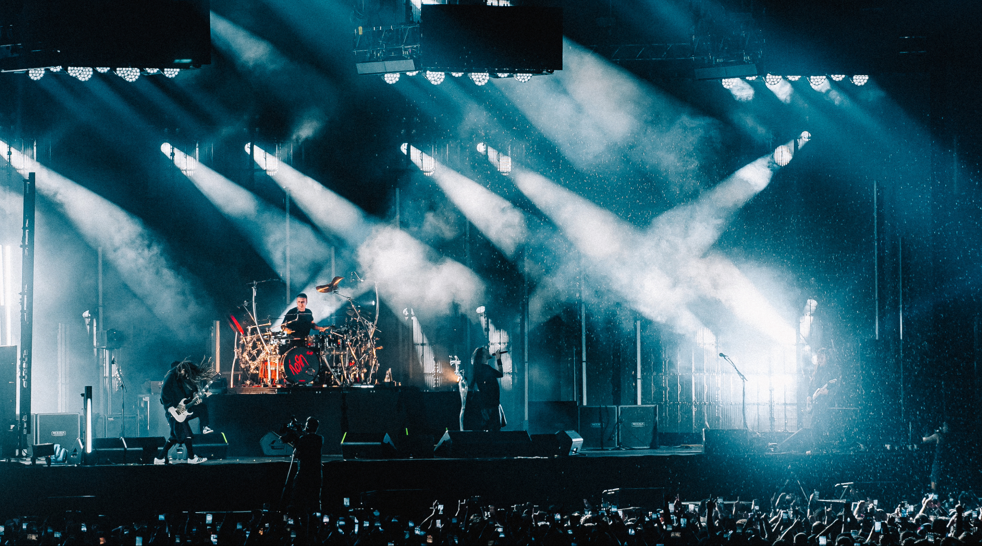 Korn durante show no Nubank Parque em São Paulo com iluminação intensa e estádio lotado