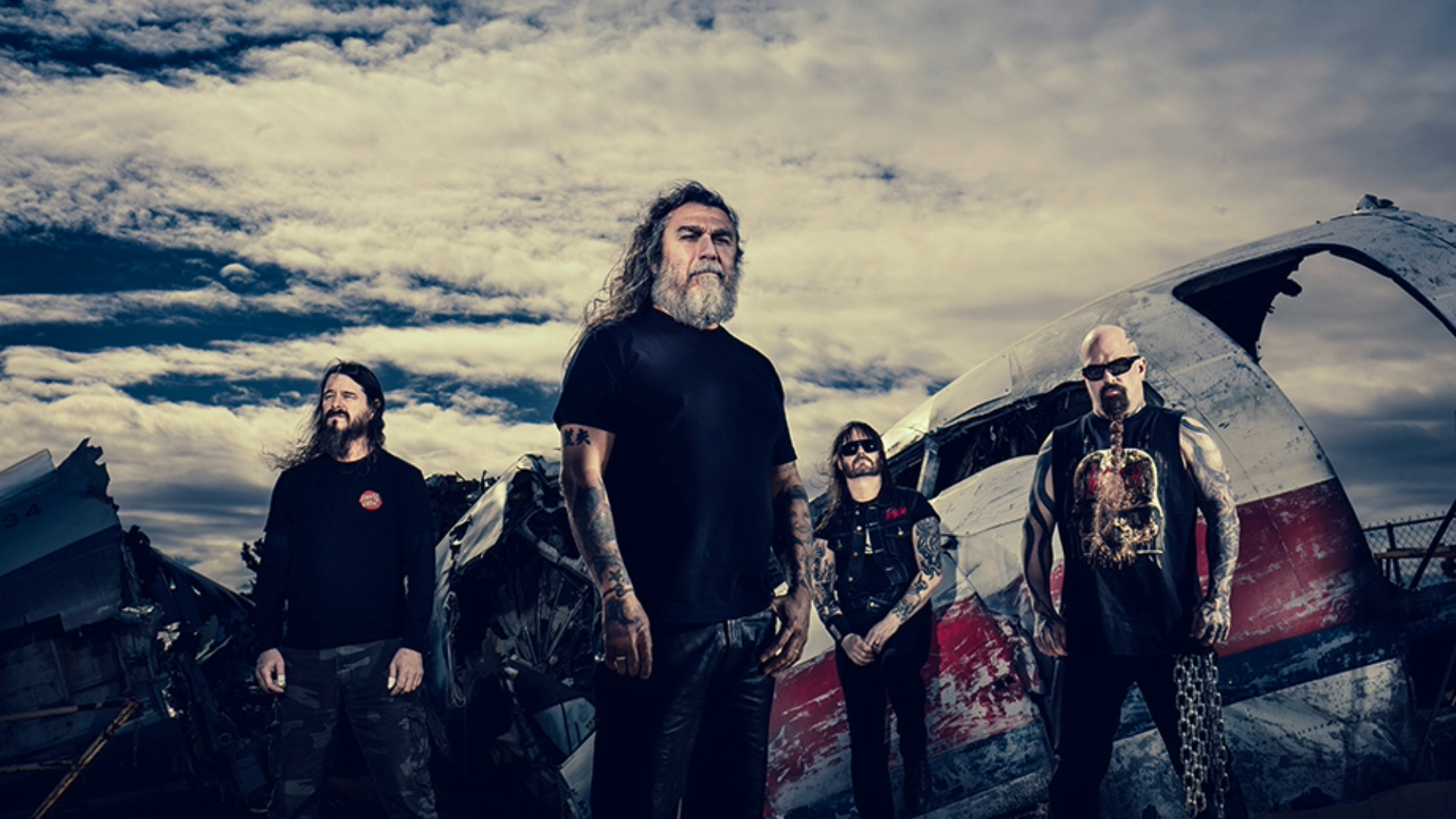 Integrantes do Slayer posam diante de destroços de avião durante divulgação do show de 40 anos do álbum Reign in Blood.