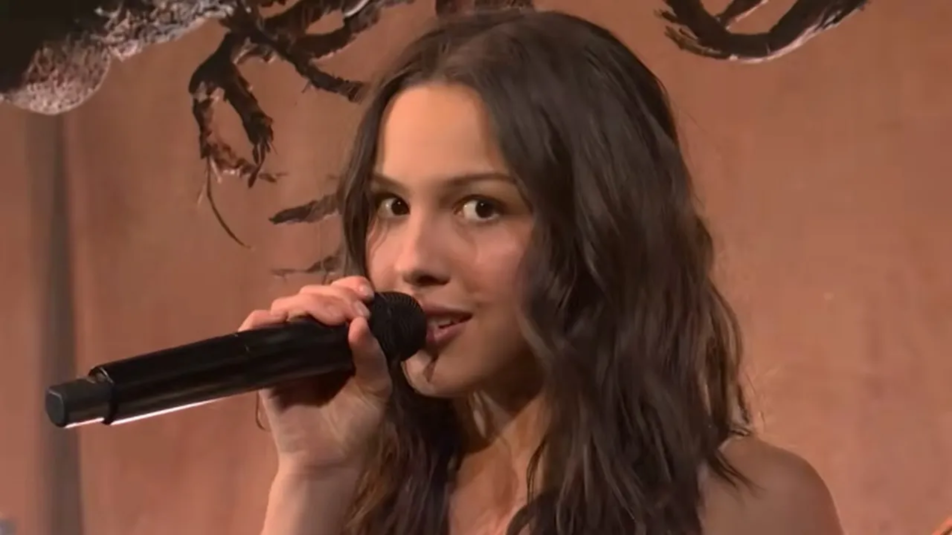 Olivia Rodrigo cantando ao vivo no SNL com microfone em close