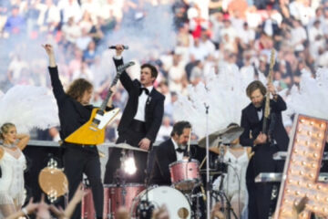 Brandon Flowers e The Killers durante apresentação na abertura da final da Champions League, acompanhados por dançarinas e produção inspirada em Las Vegas.