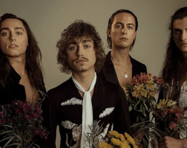 Integrantes do Greta Van Fleet posando juntos em ensaio fotográfico com flores