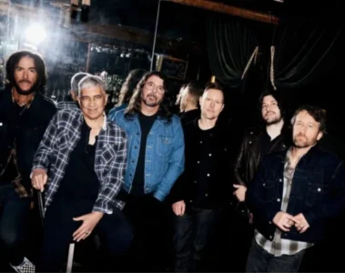 Integrantes do Foo Fighters reunidos em uma foto promocional nos bastidores, liderados por Dave Grohl.