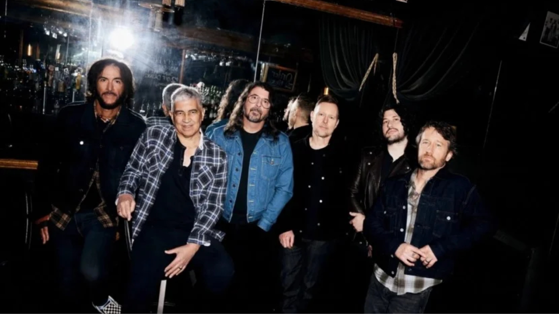 Integrantes do Foo Fighters reunidos em uma foto promocional nos bastidores, liderados por Dave Grohl.