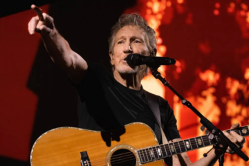 Roger Waters se apresentando ao vivo com violão durante show, integrante do Pink Floyd