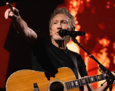 Roger Waters se apresentando ao vivo com violão durante show, integrante do Pink Floyd