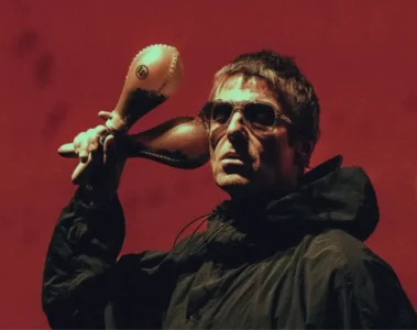 Liam Gallagher segurando suas tradicionais maracas durante apresentação. O vocalista afirmou que Be Here Now é o melhor álbum do Oasis.