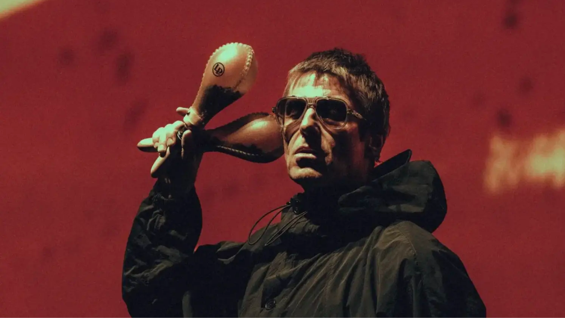 Liam Gallagher segurando suas tradicionais maracas durante apresentação. O vocalista afirmou que Be Here Now é o melhor álbum do Oasis.