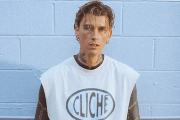 mgk posa diante de uma parede azul durante divulgação da turnê Lost Americana, que passará por São Paulo em 2026.