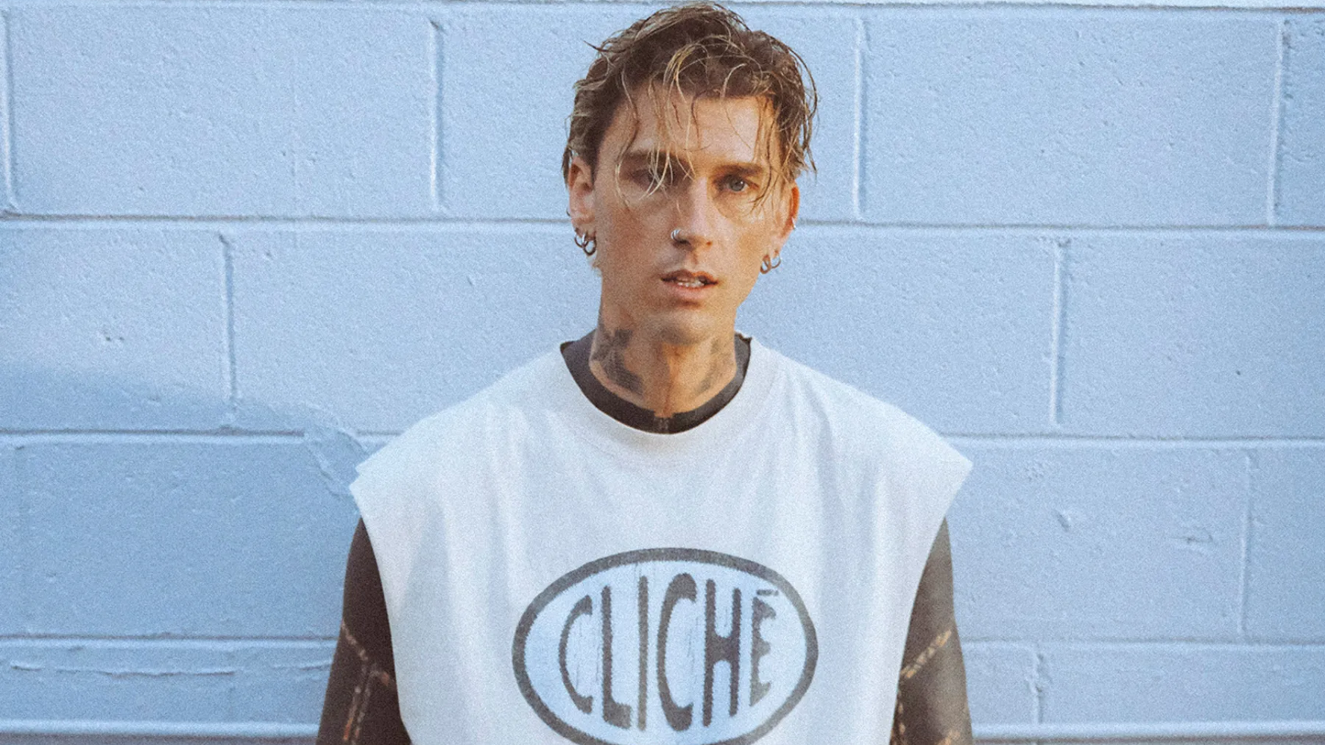 mgk posa diante de uma parede azul durante divulgação da turnê Lost Americana, que passará por São Paulo em 2026.