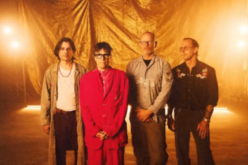 Integrantes do Weezer posam diante de um cenário dourado durante a divulgação do álbum Weezer, conhecido pelos fãs como Gold Album.