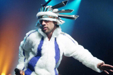 Jay Kay, vocalista do Jamiroquai, durante apresentação ao vivo; banda retorna ao Brasil para shows em 2026.