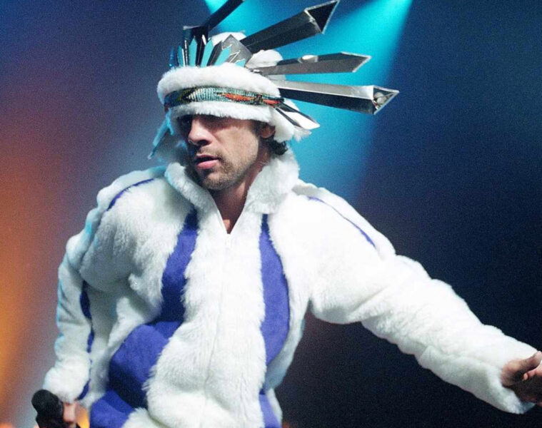 Jay Kay, vocalista do Jamiroquai, durante apresentação ao vivo; banda retorna ao Brasil para shows em 2026.
