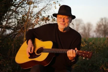 David Gilmour toca violão durante sessão ao ar livre; guitarrista recomendou o álbum Blues Breakers with Eric Clapton para jovens músicos.