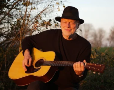 David Gilmour toca violão durante sessão ao ar livre; guitarrista recomendou o álbum Blues Breakers with Eric Clapton para jovens músicos.