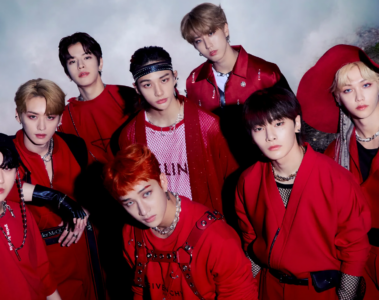 Integrantes do Stray Kids reunidos em fotografia promocional com roupas vermelhas