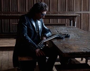 Tony Iommi sentado ao lado de sua guitarra durante a divulgação do álbum From The Dark