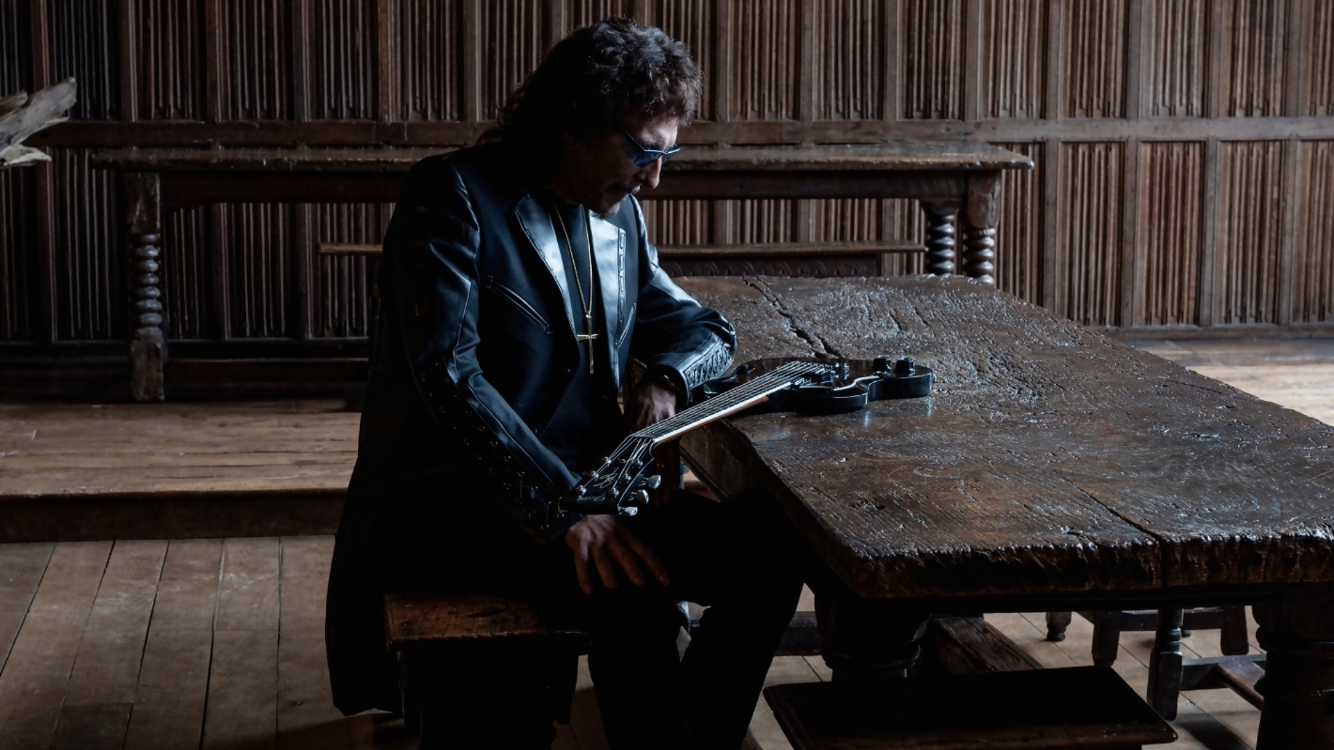 Tony Iommi sentado ao lado de sua guitarra durante a divulgação do álbum From The Dark