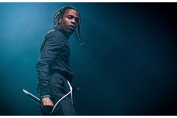 Travis Scott durante apresentação ao vivo; rapper participa da trilha sonora e do elenco de A Odisseia, novo filme de Christopher Nolan.